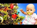 Baby Annabell doll celebrates New Year. The baby doll decorates New Year tree with toys.