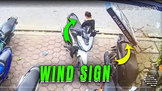 Strong Wind Blows Sign Onto Parked Bike as Girl Sits