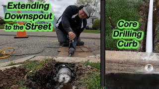 Extending a downspout to the street and coring the curb.