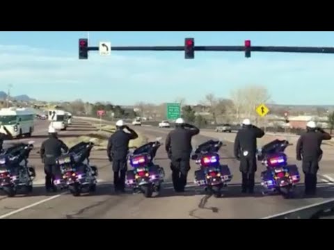 Police officers salute soldiers returning home from Afghanistan