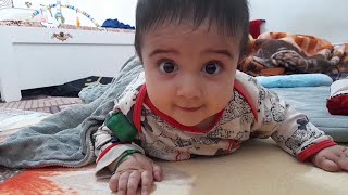 The playfulness of a 5-month-old baby sleeping on his stomach and ready to play