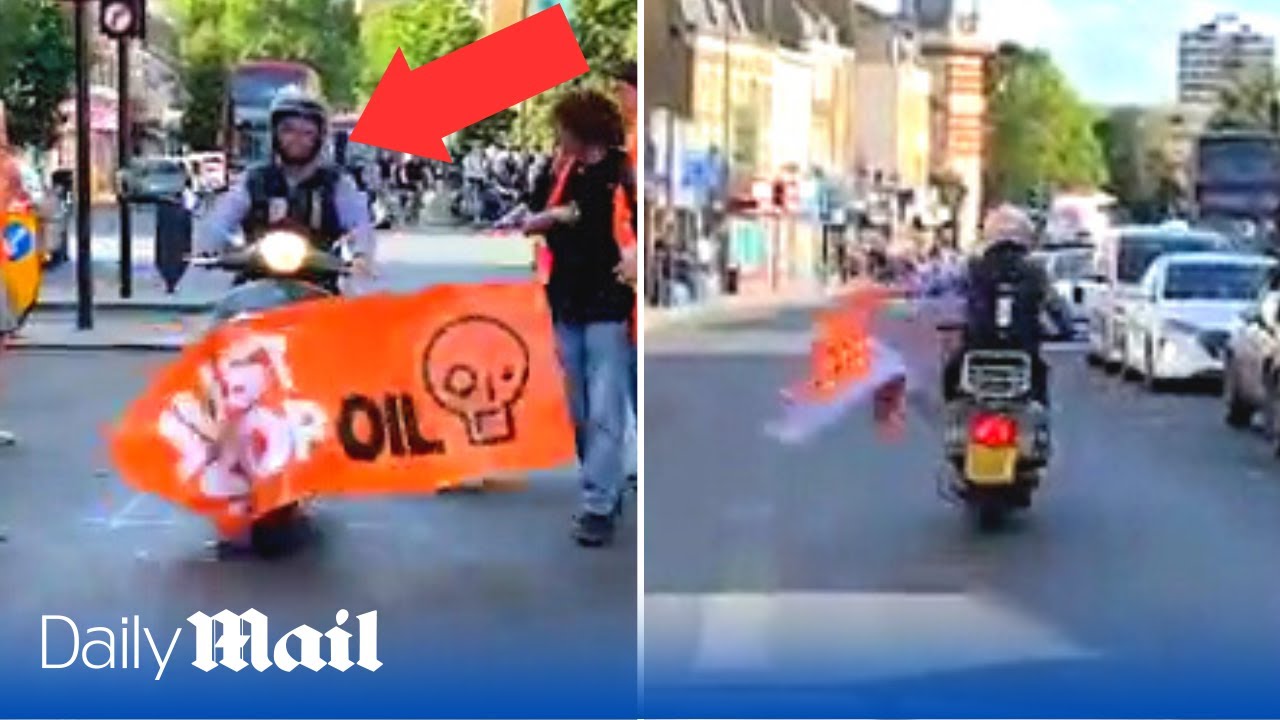 Angry motorcyclist drives straight through Just Stop Oil banner throwing it to the ground