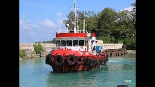 A tug and barge maneuver out of the tight confines of Angaur Dock