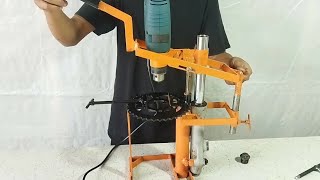 Homemade drill press with motorcycle shock absorber.