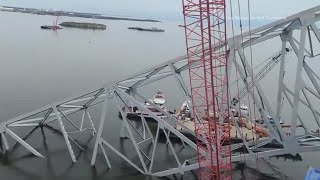 Salvage crews work to remove large section of Francis Scott Key Bridge from atop cargo ship