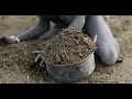 Mundari tribe boy collecting cow dungs to make bonfires to repel mosquitoes and flies south sudan