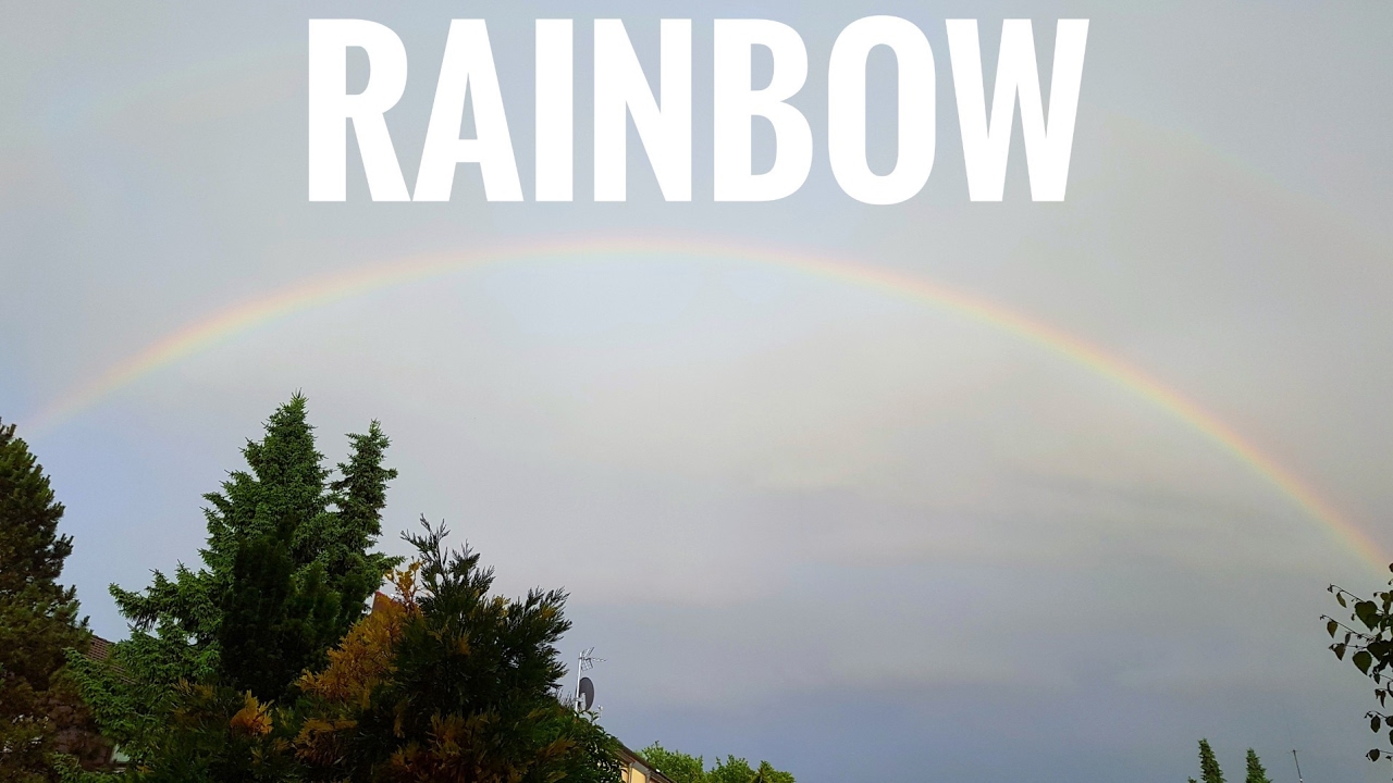 real rainbow while sun is shining and raining with thunderstorm