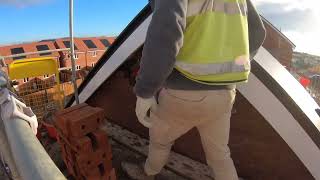 Laying moist bricks in the gable to get the house finished