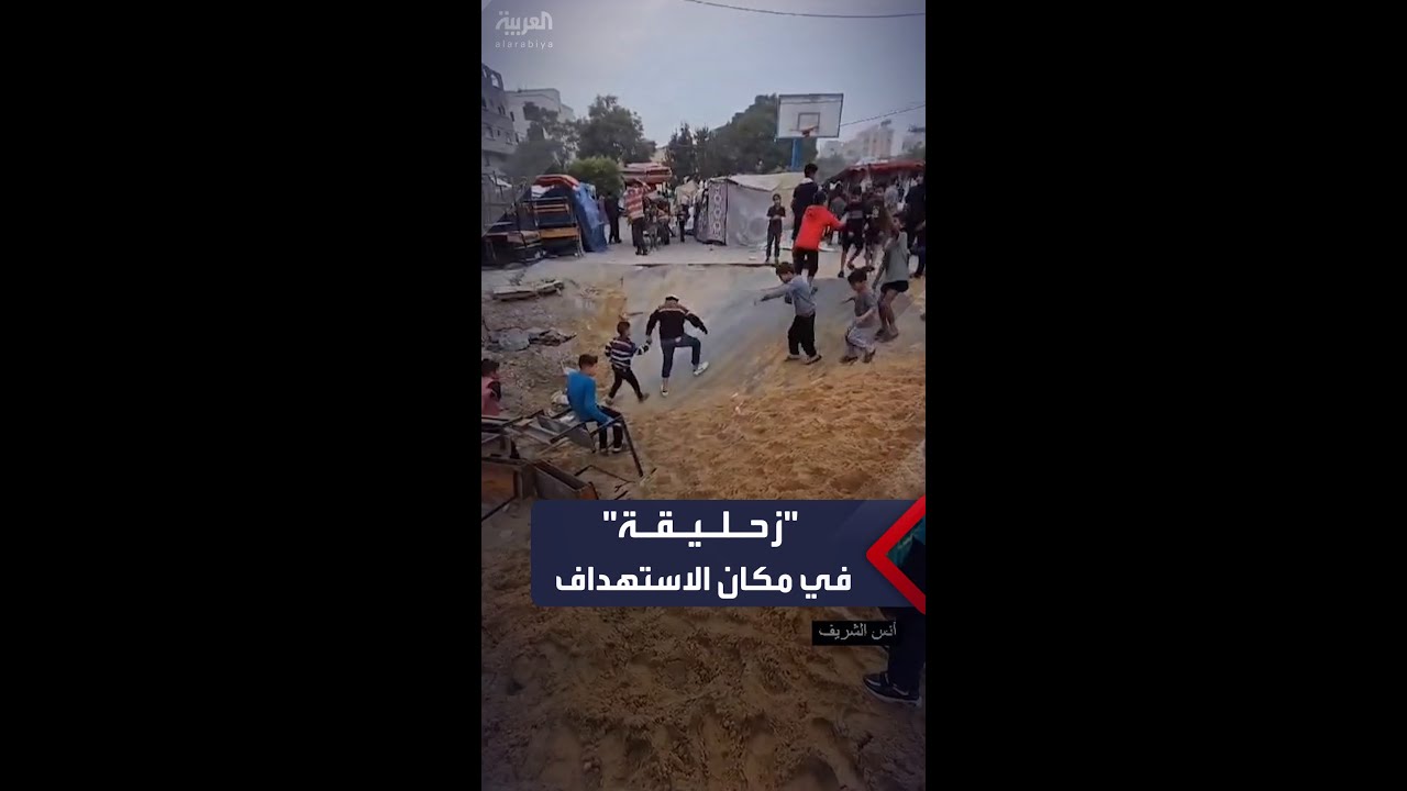 أطفال نازحون يلعبون الـ”زحليقة”في مكان استهدفته غارة وسط مدرسة إيواء في غزة