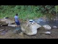 Callaloo salt fish fritters - cooking on big stone in the river