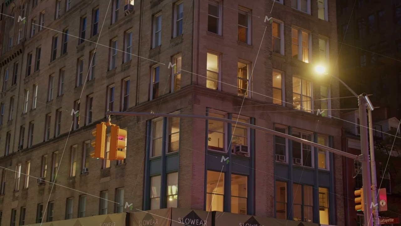 Glowing windows illuminating street corner of New York City building in Lafayette Street in NoHo