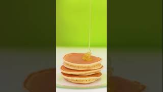 Pouring honey on medium pancakes