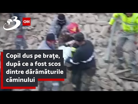 Copil dus pe braţe, după ce a fost scos dintre dărâmăturile căminului