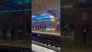 Youngmen Throwing Snowballs at Each other at a Train Station