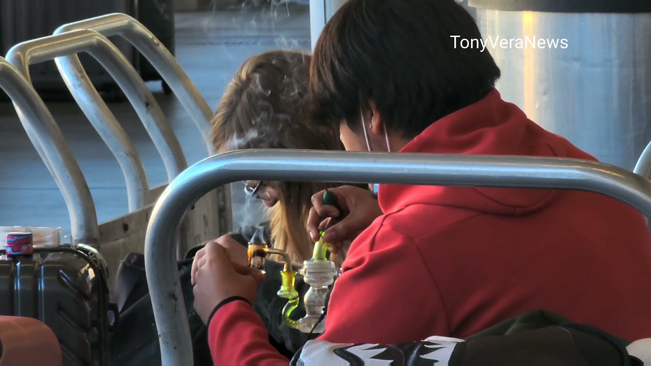 A couple Smoking THC  outside a terminal  with a Bong at LAX