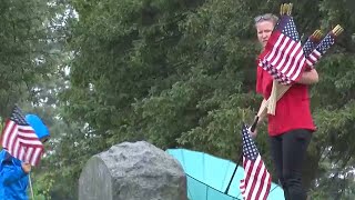 Volunteers place close to one thousand flags for veterans