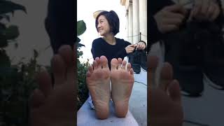asian girl takes her shoes off in public