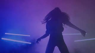 silhouette of a girl dancing energetically in the dark