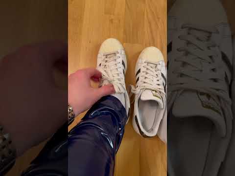 Adidas Superstar white/black/gold on feet with blue Latex Pants