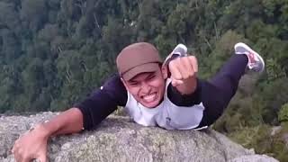 Guy Hanging Onto A Mountainside With One Hand