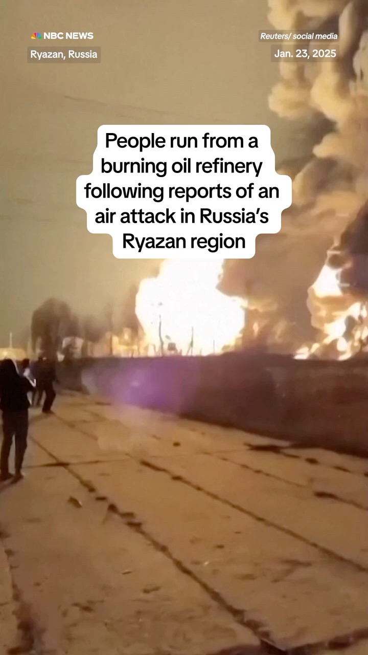 People run from a burning oil refinery following reports of an air attack in Russia's Ryazan region
