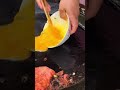 the process of pouring a mixture and eggs into a frying pan which will soon be mixed#food