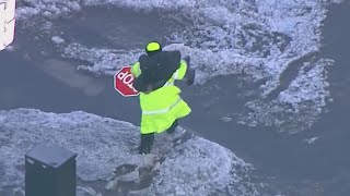 Watch as crossing guard carries child across flooded Chicago street