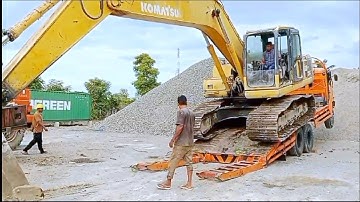 Here is the process of loading and unloading an excavator onto a self-loader truck.