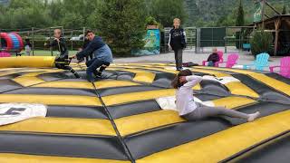 Girl gets her leg swept by swinging arm inflatable ride at the fair