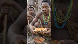 Hadzabe tribe bushman eating roast cassava with butter and pepper delicious food