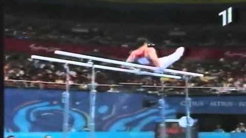 Parallel bars. From upper arm hang salto bwd with 1/2 to upper arm hang (D)
