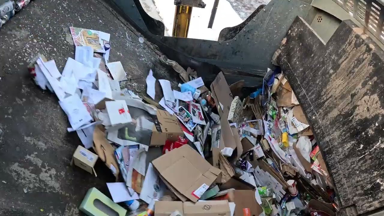 Garbage truck hopper POV: Heavy recycling collection