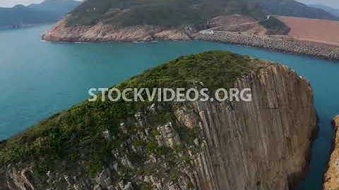 steep cliff on an island, igneous volcanic rock, basalt columns of hexagonal shape, sea view