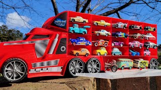 A big red truck that finds a miniature car while running in the park