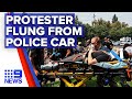 Woman jumps on police car during protest | 9News Australia