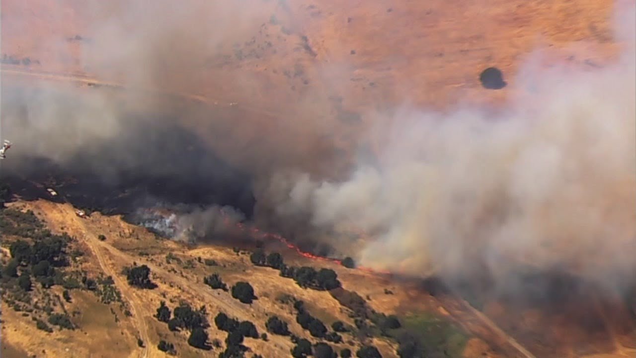 Crews battling brush fire near homes in California - YouTube