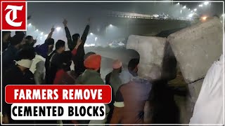 Farmers remove cemented blocks meant to stop them from marching towards Delhi at Shambu border