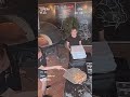 Two pizza restaurant employees have trouble picking up the pizza and getting it into the o image