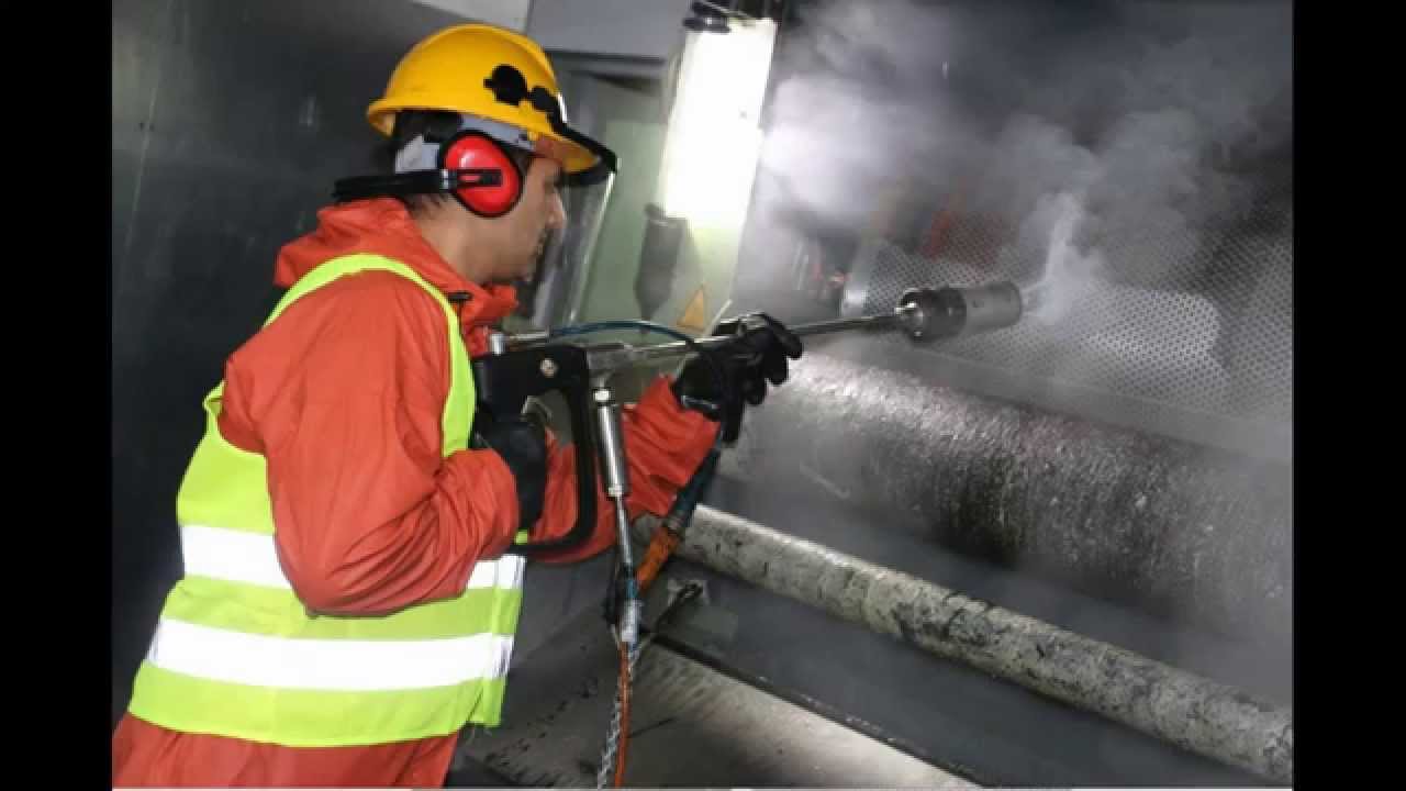Caucasian woman in PPE holding a plumber's wrench indoors, focused on maintenance.