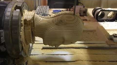 Synergy CNC 8x4 router with 4th axis cutting a 3D model of a head