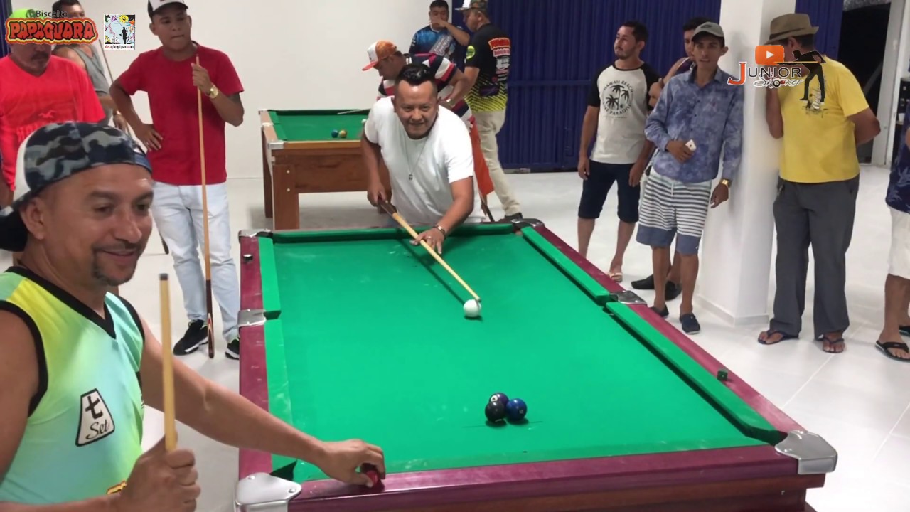 Mão do homem jogando sinuca no bar com bola de snooker