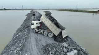 Construction of roads around the border dozer SHANTUI Push Stones into Water & 25T Truck Unloading