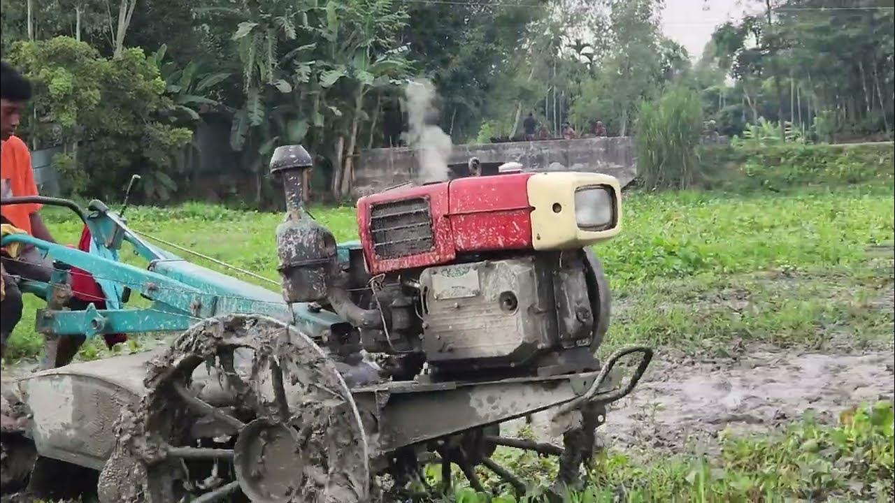 An ordinary village boy is doing agricultural work with a power tiller