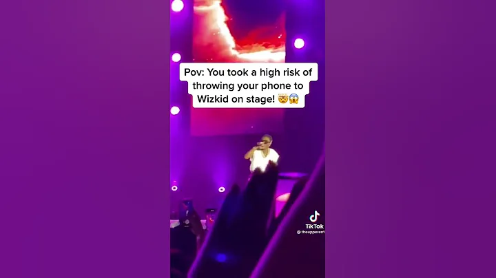 A fan took the risk and threw her phone to Wizkid on Stage