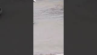 smoothing and finishing freshly poured large concrete floor surface using power trowel machine outdo