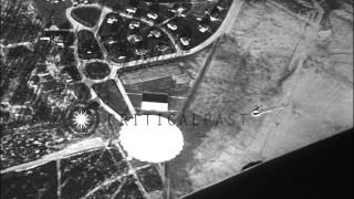 Parachutists jump one after the other from a United States Navy blimp and land sa...HD Stock Footage