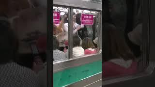 A security guard chases away a male passenger boarding a women-only carriage (205 series at Ikebu...