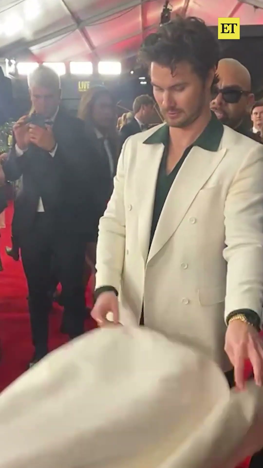 The way Chase Stokes fixes Kelsea Ballerini's dress on the #GRAMMYs red carpet is making our ❤️ melt