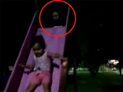 Uma mãe em choque depois de ver uma figura fantasmagórica empurrando sua filha por um escorregador