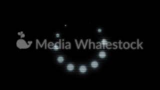 Loading white circle icon of small blinking spheres moving on black background, monochrome